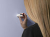 A woman using the Datacolor ColorReaderPRO on a light purple wall to determine the closest paint color match, a professional color reading device available at John Boyle Decorating Centers in Connecticut.